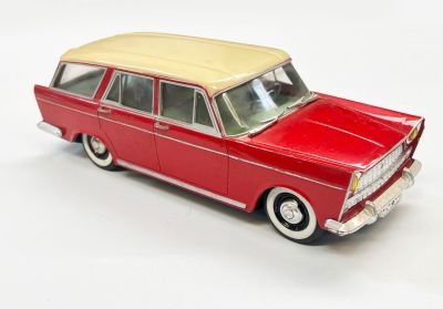 une petite voiture rouge avec un toit beige posée sur une surface blanche