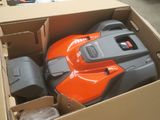 une tondeuse à gazon orange et grise rangée dans un carton