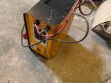 a small device that is sitting on the ground next to a trash can