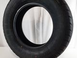 tire on a white surface with a white curtain in the background