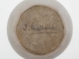 a close up of a white bowl with a brown label on it