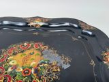 a black tray with a floral design on it