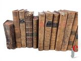 many old books lined up in a row on a white surface