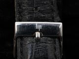 an image of a close up of a watch on a black leather strap