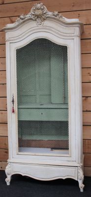 une armoire blanche munie d'une porte vitrée