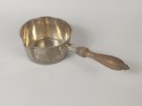 casserole plaquée argent avec un manche en bois sur fond blanc