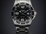 a close up of a watch on a black surface with a dark background