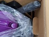 a purple vacuum in a cardboard box on the floor