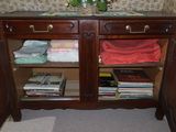 a wooden cabinet with books and magazines on it