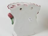 a white vase with a flower in it on a table