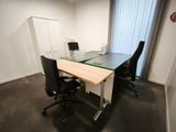 un bureau avec deux chaises et un ordinateur dessus