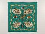 un foulard en soie vert orné d'un motif représentant des chiens, accroché au mur