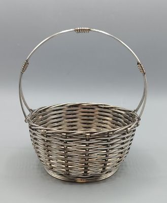 a silver plated basket with a handle