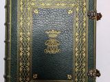 un livre en cuir vert, orné de bordures dorées et d'un motif décoratif
