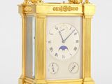 une horloge en or posée sur une surface blanche