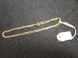 a gold chain and a white tag on a table