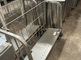 de nombreuses tables et chariots en acier inoxydable dans un entrepôt