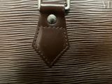 a close up of a brown leather bag with a metal buckle