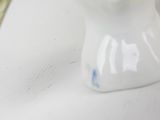 a small figurine of a snowman holding a branch of a tree