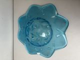 a blue glass bowl with a flower design on it