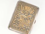 silver and gold cigarette case with a dragon design on the front