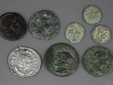 six pièces de monnaie romaines anciennes, dont l'une représente une tête de lion et l'autre une tête de lion