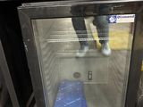 a glass door that is open to show a blue container