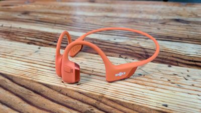 un casque audio orange posé sur une table en bois