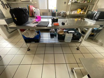une photo d'une cuisine avec une table et un micro-ondes