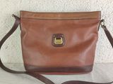 a brown leather purse with a brown strap sitting on a table