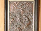 une photo d'un relief en métal sur un mur en bois
