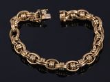 a gold chain bracelet with a clasp on a black surface