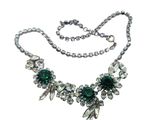 necklace with green stones and silver beads on a white background