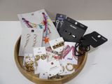 un bol en bois rempli d'un assortiment de bijoux et de boucles d'oreilles