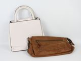 un sac à main beige et blanc à côté d'un porte-monnaie blanc sur fond blanc