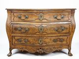 une vieille commode en bois avec des sculptures ornementales sur les tiroirs