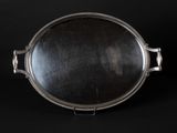 an antique silver plate on a black background with a reflection in it