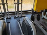 a gym room with a row of stationary exercise bikes
