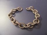 rope bracelet on a black surface with a silver clasp