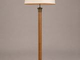 un lampadaire en bois surmonté d'un abat-jour blanc