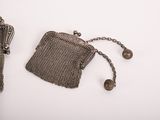 an antique silver mesh purse with a chain around it and a chain hanging from it