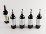 six bottles of wine are lined up in a row on a white surface