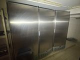stainless steel refrigerators in a commercial kitchen with tiled flooring