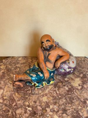 une figurine représentant un homme assis sur un lit