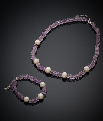 un gros plan d'un collier et d'un bracelet ornés de perles sur fond noir
