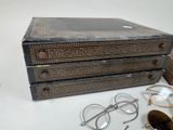 une pile de livres, avec des verres et une paire de lunettes