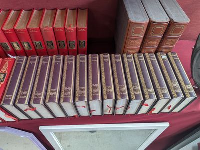 several books are stacked on a table in front of a laptop