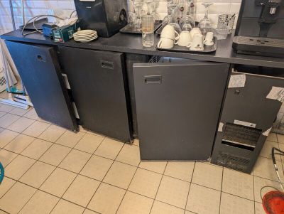 une cuisine où le plan de travail est encombré d'appareils électroménagers et de vaisselle