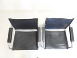 two black chairs sitting next to each other on a white surface