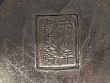 a close up of a metal object with a chinese writing on it